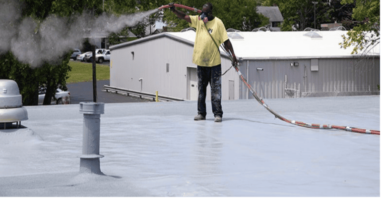 Worker with hose on roof